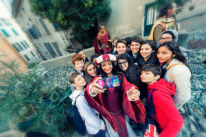 Gruppo di ragazzi che si fanno un selfie con donna in abiti medioevali